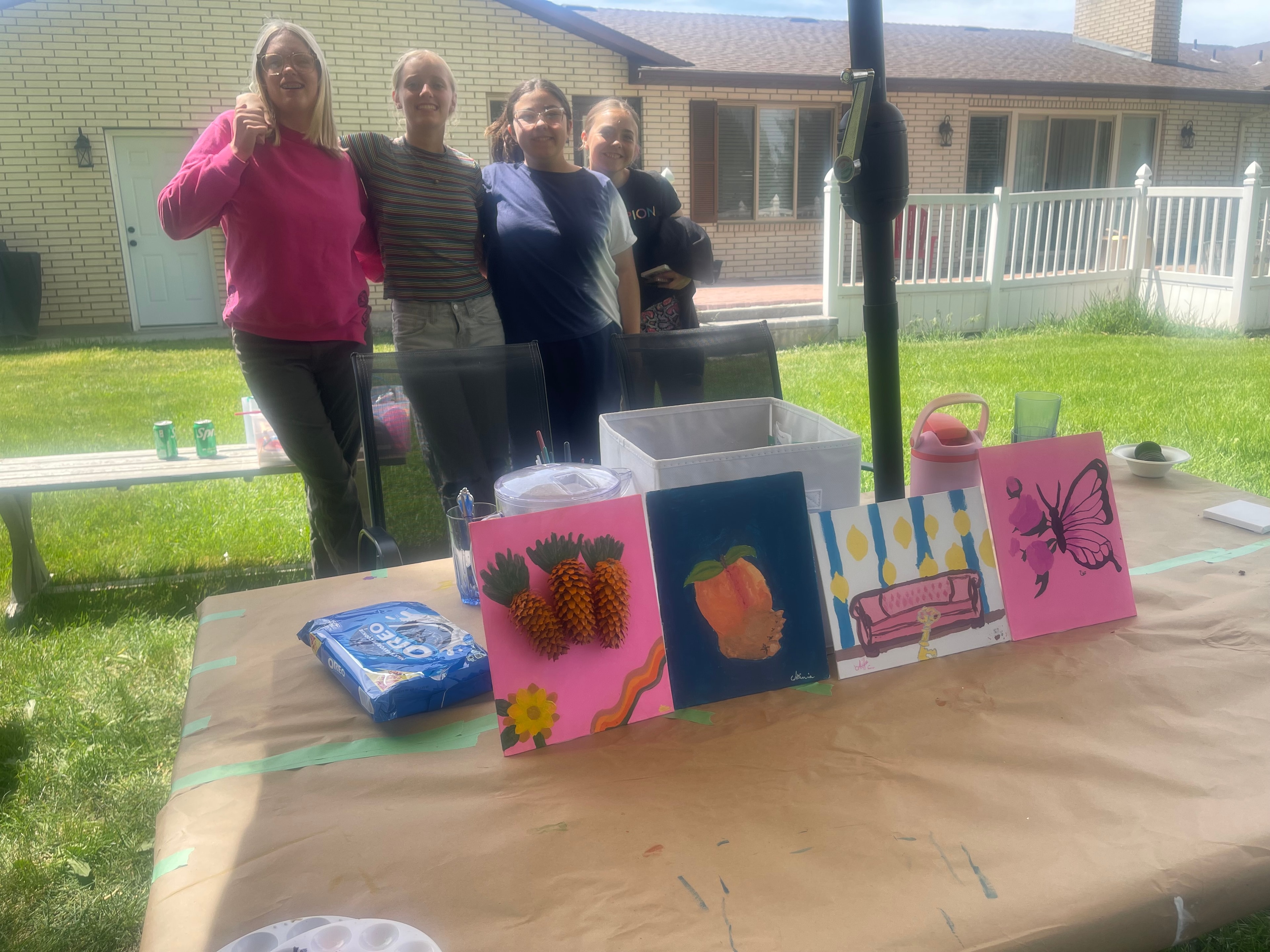 Participants showing finished artwork at the Crown Up painting event